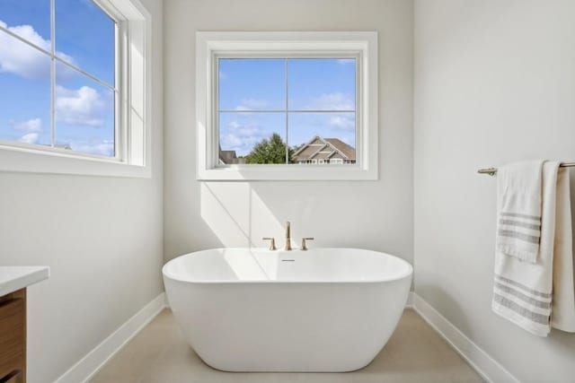 14237 Mckenna Rd NW, Prior Lake, MN 55372 - bathroom featuring baseboards, a freestanding tub, tile patterned floors, and vanity
