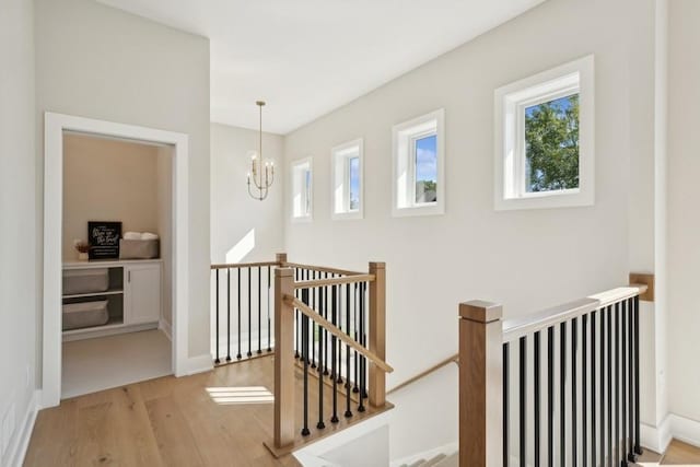 14237 Mckenna Rd NW, Prior Lake, MN 55372 - hall featuring a notable chandelier, an upstairs landing, a wealth of natural light, and wood finished floors