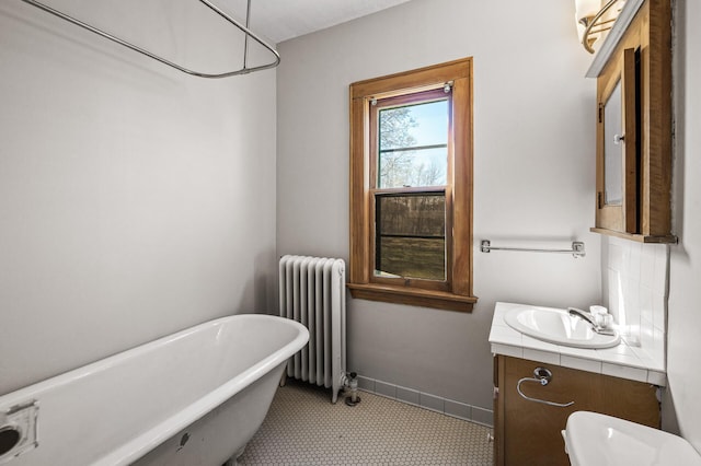 full bathroom with a soaking tub, radiator heating unit, and vanity