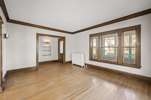 unfurnished living room with baseboards, ornamental molding, radiator, and light wood finished floors