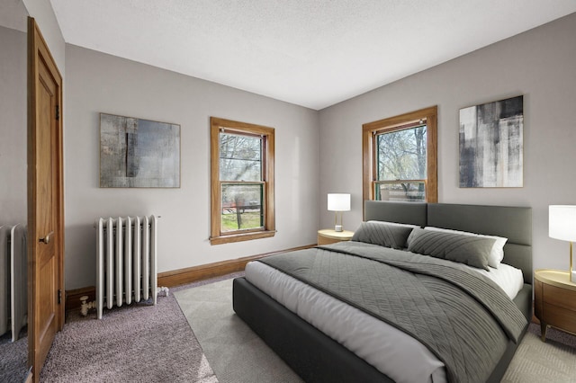 bedroom featuring baseboards, light colored carpet, multiple windows, and radiator heating unit