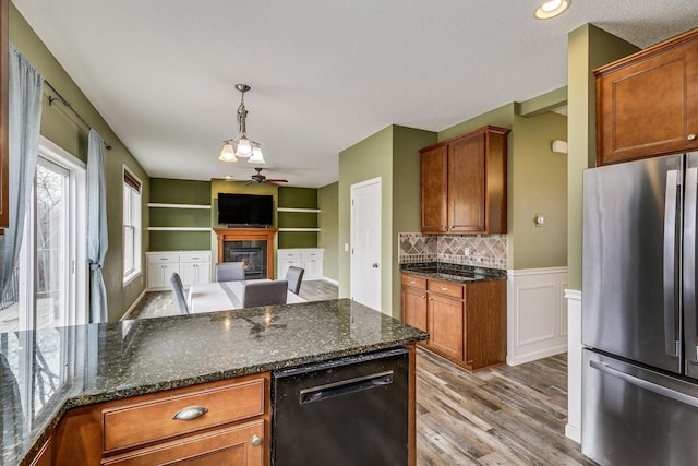 kitchen with ceiling fan, dishwasher, a glass covered fireplace, freestanding refrigerator, and light wood-type flooring