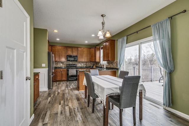 dining area with dark wood-type flooring, recessed lighting, visible vents, and an inviting chandelier