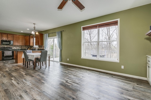 dining room featuring baseboards, dark wood-style flooring, and ceiling fan with notable chandelier