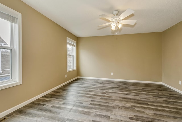 spare room featuring baseboards, a ceiling fan, and wood finished floors