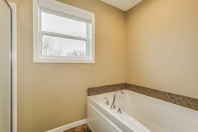 bathroom featuring baseboards and a garden tub