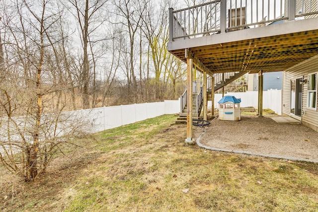 view of yard featuring a patio, a deck, stairs, and a fenced backyard