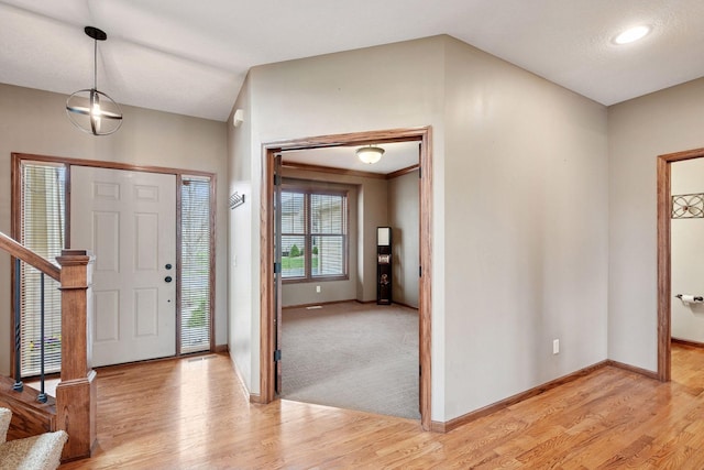 entrance foyer with baseboards, light wood-style flooring, and stairs