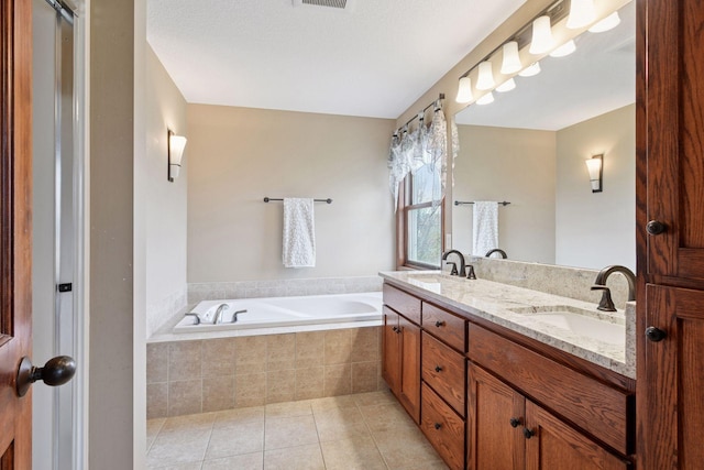 full bath featuring a garden tub, a sink, tile patterned flooring, and double vanity