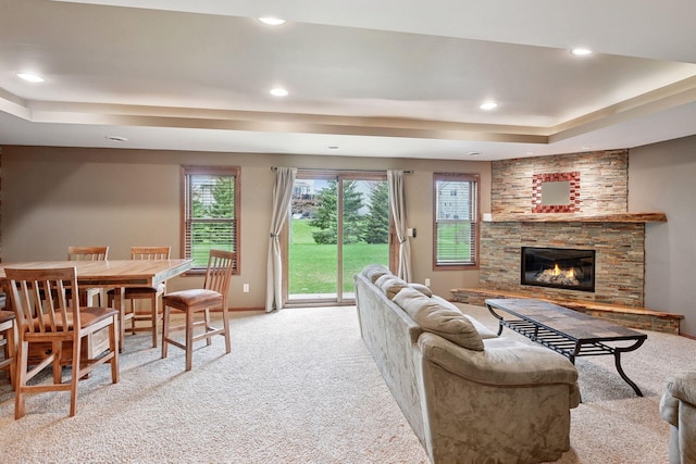 living area featuring carpet flooring, recessed lighting, a tray ceiling, and a fireplace