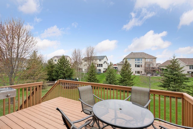 deck featuring a lawn, a residential view, and outdoor dining area