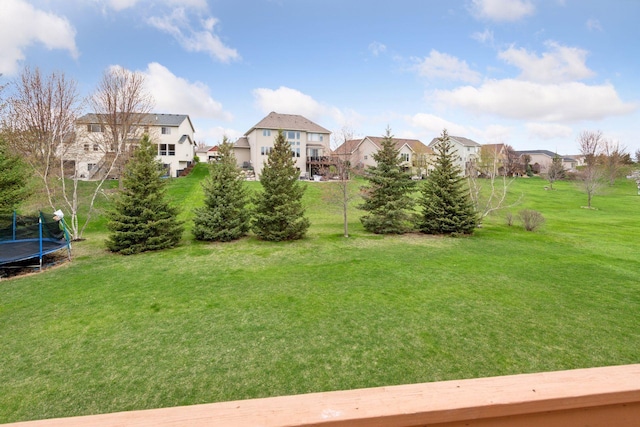 view of yard featuring a residential view and a trampoline