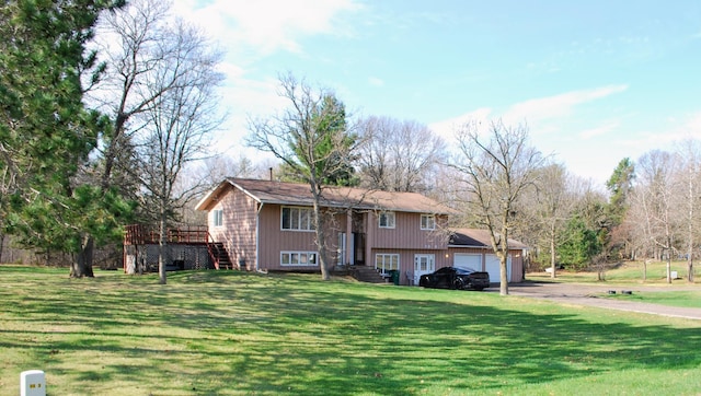 bi-level home featuring a wooden deck, an attached garage, aphalt driveway, and a front yard