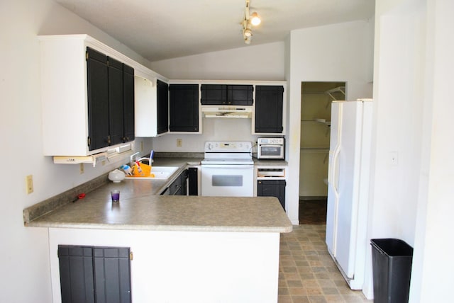kitchen featuring a peninsula, lofted ceiling, white appliances, dark cabinetry, and a sink