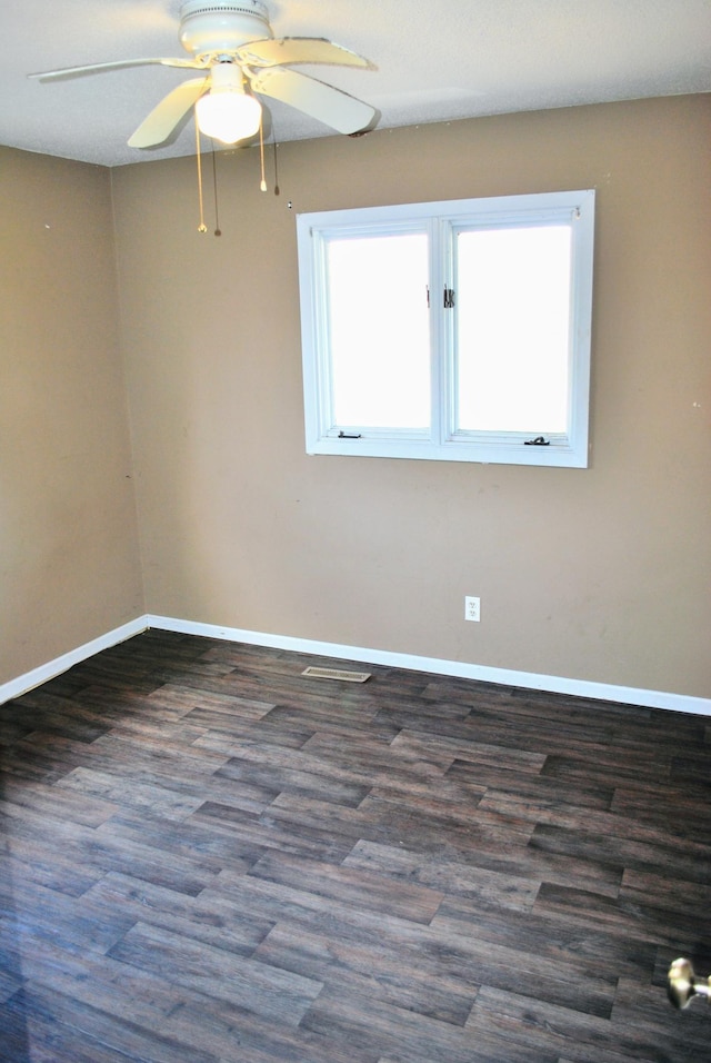 spare room featuring baseboards, a ceiling fan, and wood finished floors