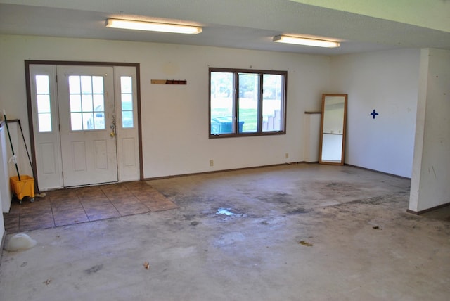 entrance foyer with baseboards, concrete flooring, and a wealth of natural light