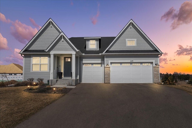 view of front of house with driveway and stone siding