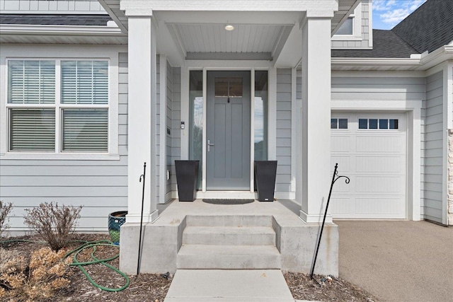 property entrance with an attached garage and a shingled roof