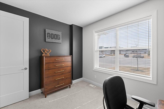 home office with baseboards, visible vents, and light carpet