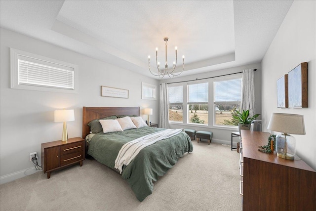 bedroom with baseboards, a chandelier, light carpet, and a raised ceiling