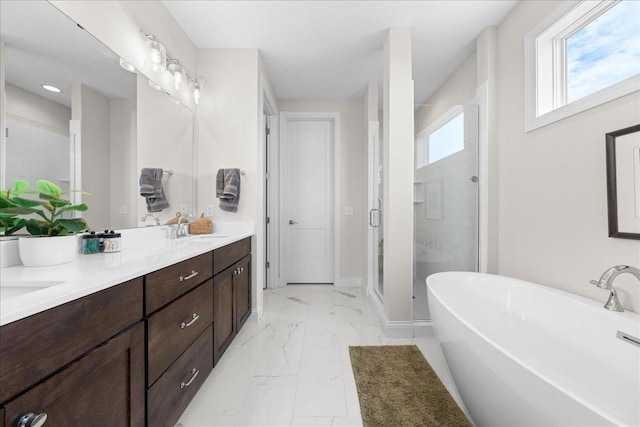 full bath featuring double vanity, a freestanding tub, a shower stall, a sink, and marble finish floor