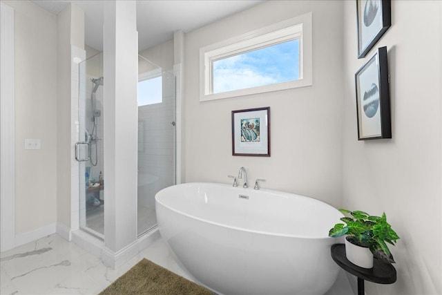 bathroom with baseboards, a shower stall, a soaking tub, and marble finish floor