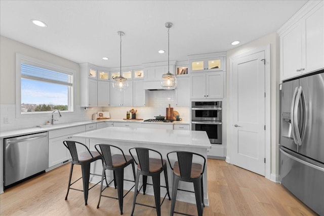kitchen with a sink, backsplash, a breakfast bar, and stainless steel appliances