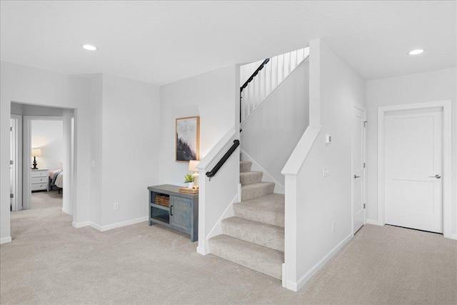 staircase with baseboards, recessed lighting, and carpet