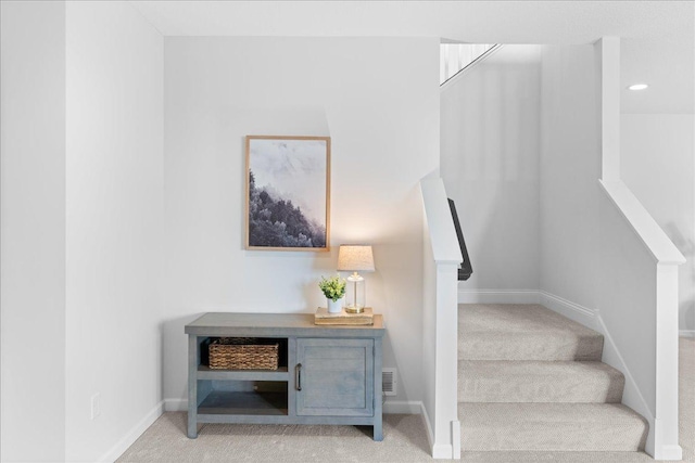 stairway featuring baseboards, visible vents, and carpet