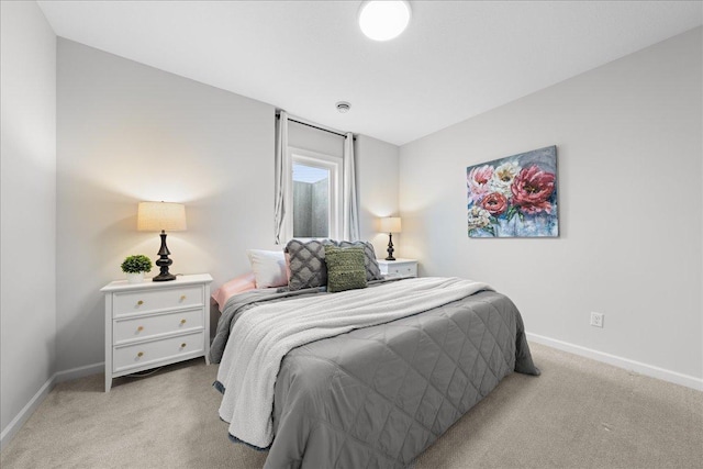 bedroom with baseboards and light carpet