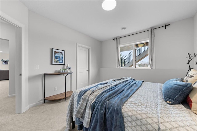 bedroom featuring baseboards and light colored carpet