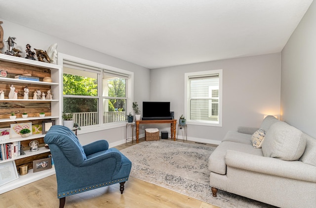 living area featuring healthy amount of natural light, wood finished floors, and baseboards
