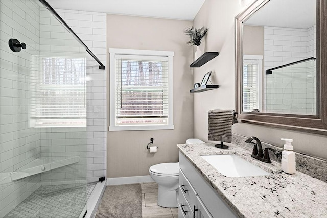 full bathroom featuring tile patterned flooring, vanity, toilet, baseboards, and a shower stall