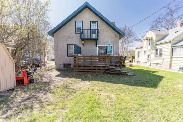 312 Vine St, Fergus Falls, MN 56537 - back of house featuring a wooden deck, stucco siding, and a lawn