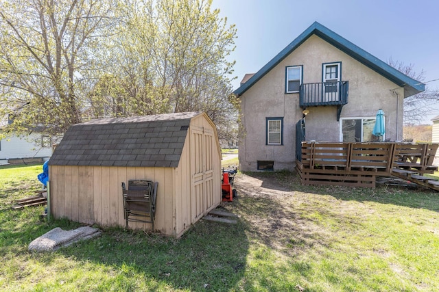 312 Vine St, Fergus Falls, MN 56537 - rear view of house with a storage shed, an outdoor structure, a balcony, stucco siding, and a lawn