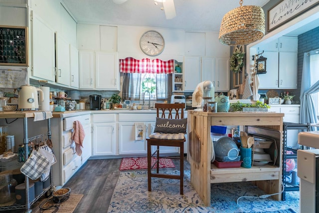 312 Vine St, Fergus Falls, MN 56537 - kitchen with a sink, dark wood-style flooring, white cabinetry, light countertops, and a ceiling fan