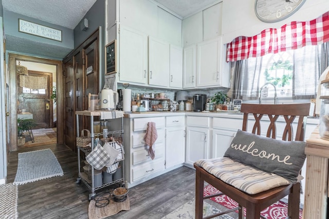 312 Vine St, Fergus Falls, MN 56537 - kitchen with light countertops, dark wood finished floors, tasteful backsplash, and white cabinetry