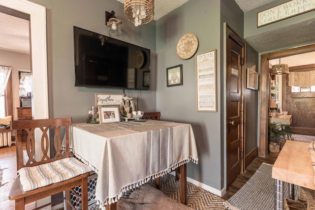 312 Vine St, Fergus Falls, MN 56537 - interior space featuring an inviting chandelier, a textured ceiling, wood finished floors, and baseboards