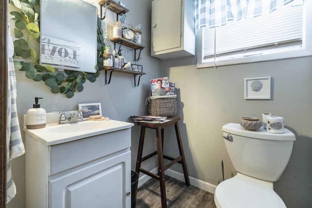 312 Vine St, Fergus Falls, MN 56537 - half bathroom with toilet, baseboards, wood finished floors, and vanity