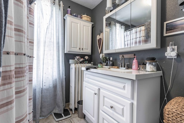 312 Vine St, Fergus Falls, MN 56537 - bathroom featuring vanity, a textured wall, a shower with curtain, and radiator heating unit