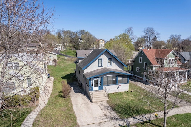 312 Vine St, Fergus Falls, MN 56537 - view of front of home with concrete driveway, a front yard, stucco siding, and a residential view