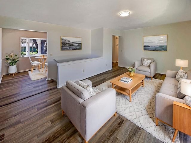 living room with dark wood-type flooring and baseboards