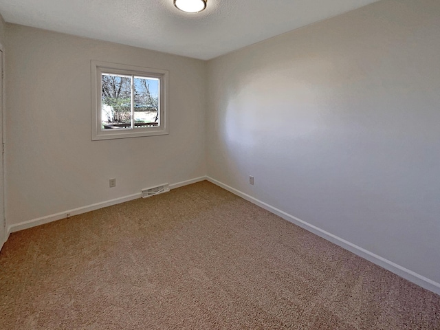 unfurnished room with baseboards, carpet flooring, and visible vents