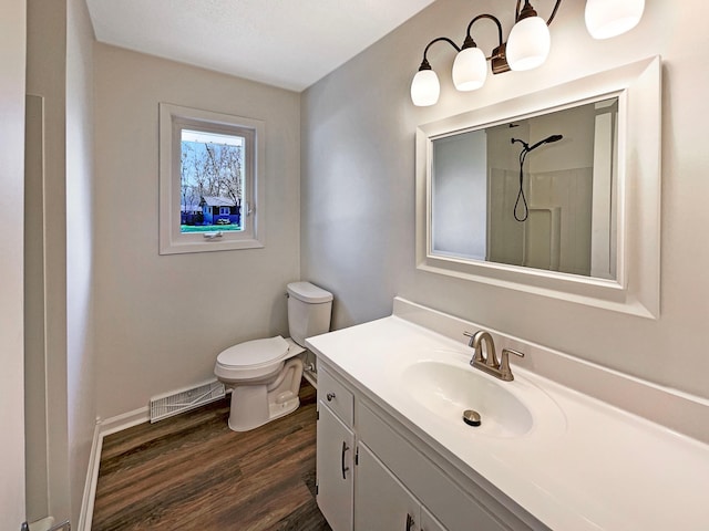 full bathroom featuring walk in shower, vanity, toilet, wood finished floors, and visible vents