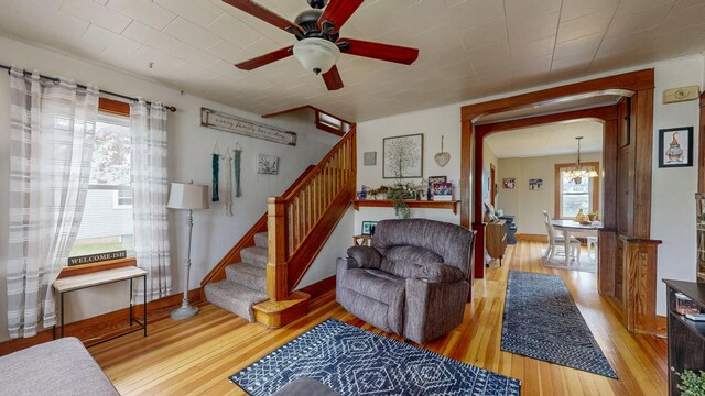621 Fillmore St SE, Chatfield, MN 55923 - living area with hardwood / wood-style flooring, arched walkways, ceiling fan, and stairway