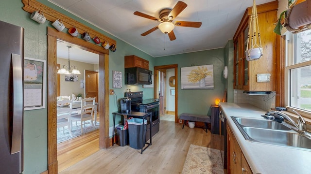 621 Fillmore St SE, Chatfield, MN 55923 - kitchen with black appliances, a sink, light wood finished floors, a ceiling fan, and a chandelier