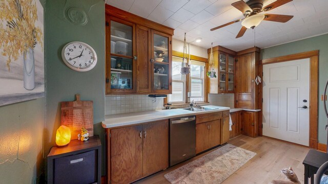 621 Fillmore St SE, Chatfield, MN 55923 - kitchen with stainless steel dishwasher, brown cabinetry, backsplash, and light wood-style floors