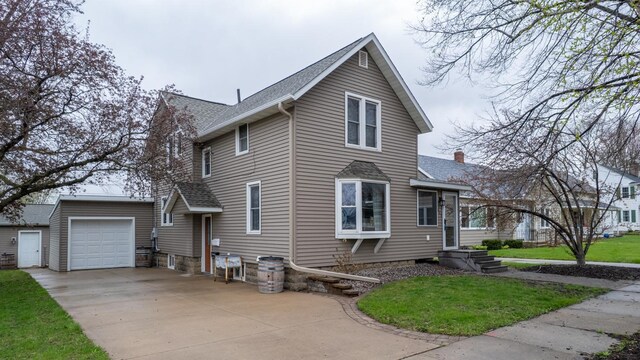 621 Fillmore St SE, Chatfield, MN 55923 - view of front of house featuring driveway, a front lawn, a shingled roof, and a garage