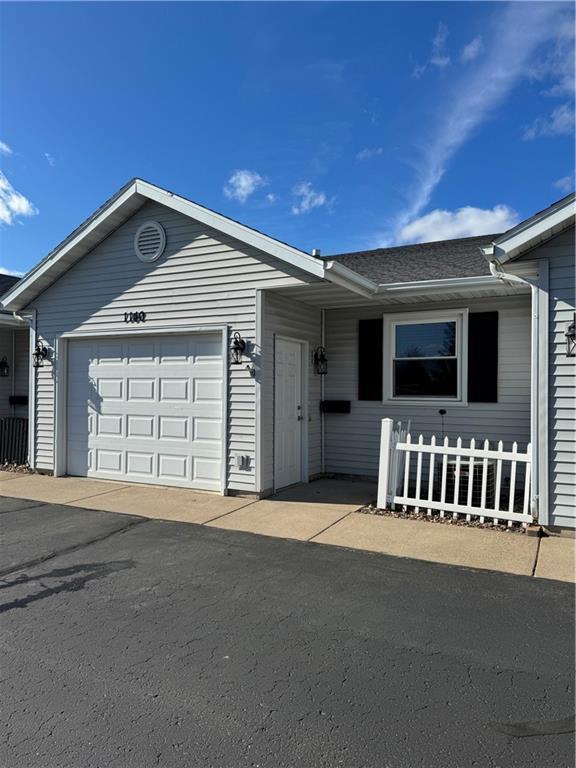 ranch-style house with an attached garage, fence, and a shingled roof
