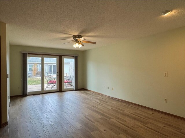 unfurnished room featuring baseboards, a textured ceiling, ceiling fan, and wood finished floors